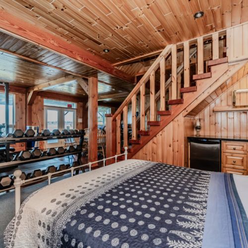 Lower-level bedroom opens to gym and dining space, featuring mini-fridge and sink—perfect for flexible stays, multi-family trips, or extended rentals.