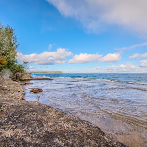 Discover the rugged charm of Isthmus Bay from this waterfront vantage point. Perfect for water activities or simply relaxing by the bay after visiting the Grotto or Flowerpot Island.