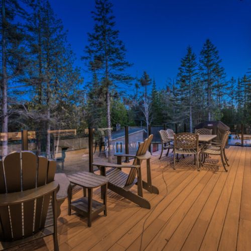 Spacious deck at this vacation rental features outdoor seating, a BBQ grill, and forest views—ideal for relaxing getaways, family BBQs, and enjoying serene cottage evenings.