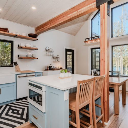 Whip up meals with a view in this bright, open-concept kitchen featuring lake-facing windows, a central island, and charming farmhouse details—perfect for cozy getaways, weekend escapes, and unforgettable cottage vacations.