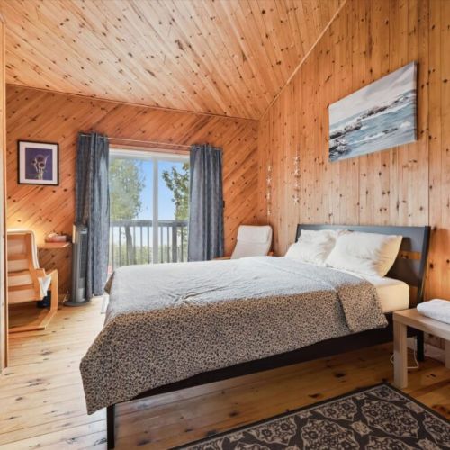 Bedroom 1: Comfortable bedroom with direct walkout to the deck—enjoy fresh air and peaceful lake views.