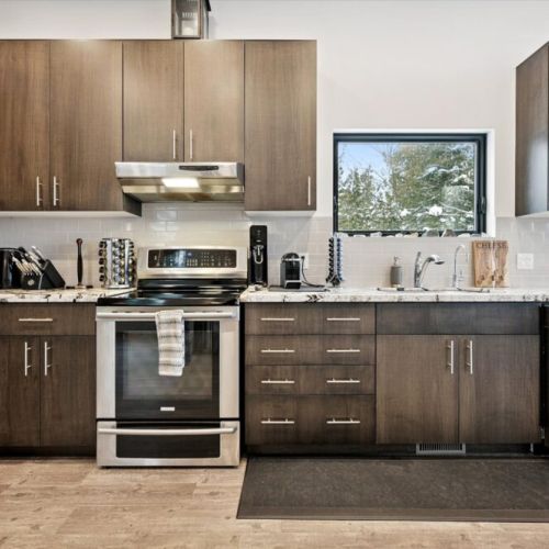 Clean lines and functional design define this bright kitchen workspace, with forest views and everything you need for a comfortable stay.