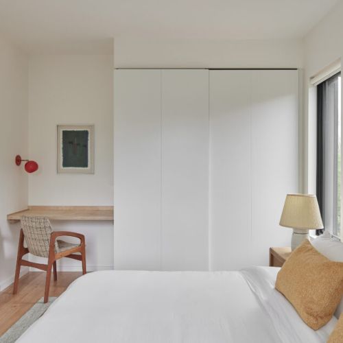 A bedroom with a built-in desk, perfect for a quiet workspace, complemented by modern decor.