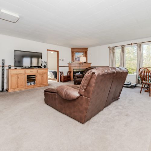 Another view of the spacious living area with large windows, perfect natural lighting, and easy access to bedrooms and entertainment.