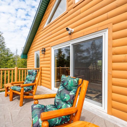 Enjoy the spectacular Huron sunsets from the Juliet balcony. Another view of the balcony showcases the attention to detail in the log construction and the seamless connection between indoor and outdoor living spaces.