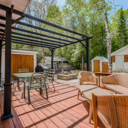 Relax on the deck, complete with comfortable seating and a shaded pergola.