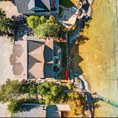 Escape to luxury on the crystal-clear shores of Isthmus Bay. This aerial view of the Lion's Den property captures the spacious layout and direct waterfront access, just minutes from Lion’s Head.