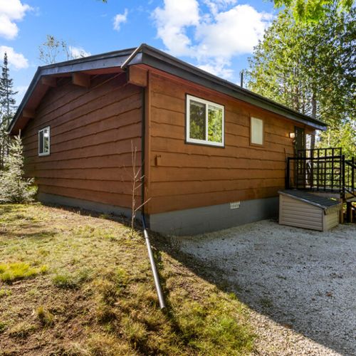 The side of the cottage offers ample outdoor space and easy access to the surrounding forest.