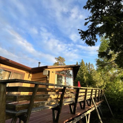 Steps into serenity on this elevated deck, where rustic charm meets the peaceful beauty of nature, perfect for unwinding with a view of the lush surroundings.