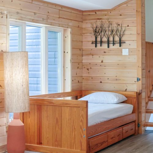 Welcoming & Accessible:
This welcoming bedroom features a comfortable daybed, perfect for guests with limited mobility. Enjoy the beautiful lake views and relax in this accessible space. 
This is designed with both families and accessibility in mind.