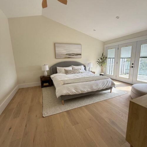 Unwind in a spacious king suite with vaulted ceilings, walk-out deck access, and natural textures for a boutique-hotel feel.