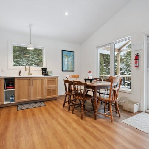 Sun-filled dining area with forest views, perfect for shared meals, board games, or planning your next Bruce Peninsula adventure.