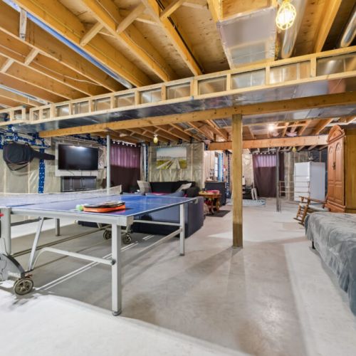 Step from the workout room into the games room featuring ping pong, a dart board, acoustic guitar, and electric piano for relaxing or having fun. Best of all, enjoy direct basement access to the outside.