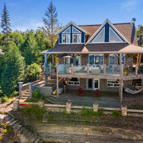 The Lion's Den Cottage, perched right on the edge of Georgian Bay, with panoramic views and direct access to the water. The perfect retreat for a peaceful getaway.