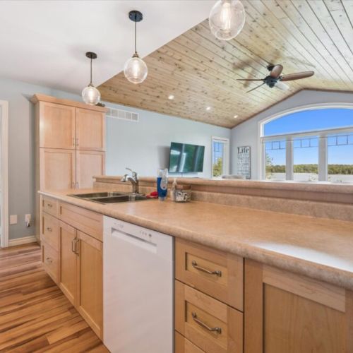 Spacious kitchen island with sink and seating, offering beautiful views of the lake while you cook or gather.