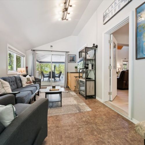 Relaxing sunroom lounge with easy access to the outdoor deck and beautiful surrounding scenery.