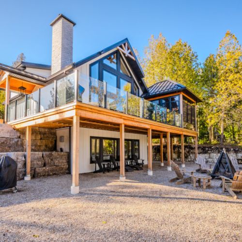 This stunning vacation rental offers a modern cottage escape with a spacious deck, floor-to-ceiling windows, and a cozy fire pit—perfect for nature retreats, weekend getaways, and outdoor living near the lake.