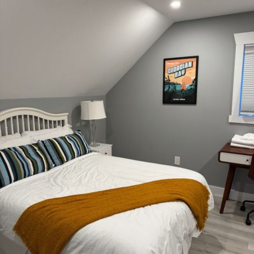 Cozy loft bedroom at Sunset Bay with crisp linens and calm, modern cottage vibes. A perfect place to recharge after a day by the water.