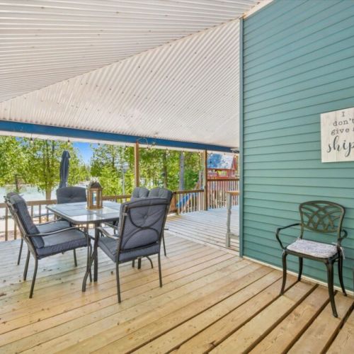 Large covered outdoor living space offering comfortable seating and peaceful views of the surrounding property.