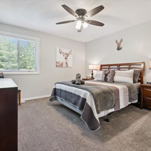 Comfortable guest bedroom with soft bedding, warm décor, and peaceful forest views.