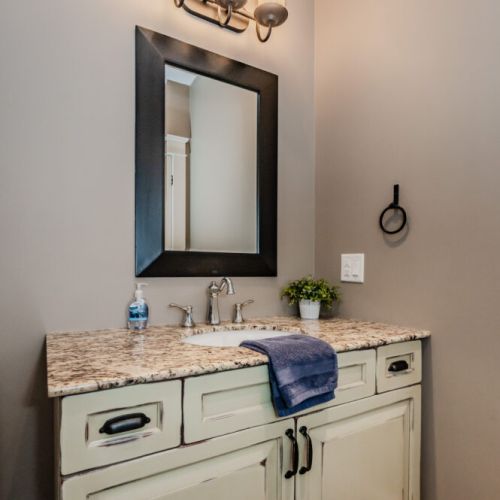 A stylish bathroom with a granite countertop, soft lighting, and elegant decor, creating a warm, welcoming atmosphere.