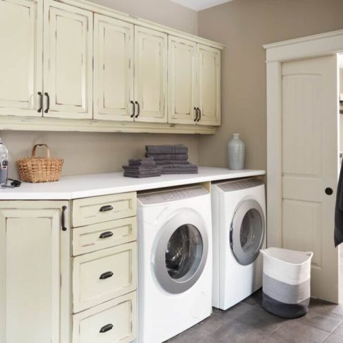 Charming laundry room featuring vintage-style cabinetry, modern appliances, and ample storage—combining functionality with classic design.