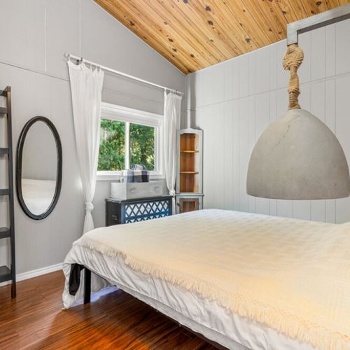 Wake up surrounded by warm wood finishes in the peaceful primary bedroom with queen bed.