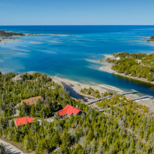 Spectacular lakefront setting with private docks and red-roofed cottage—your dream destination for waterfront vacations, paddling, and unforgettable sunsets.