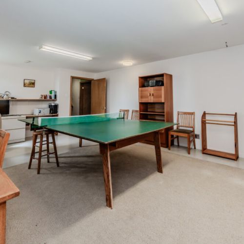 Large recreation room with a ping pong table and lounge area—great for rainy day fun or evening entertainment with family and friends.