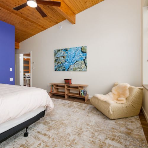 The spacious primary bedroom includes a cozy reading nook and warm natural finishes throughout.