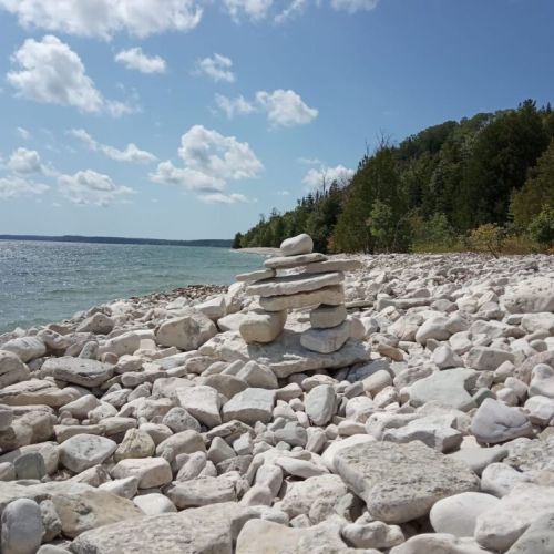 Inukshuk on the beach. (Photo by Zach Brown, Unsplash). Take a short drive to Tobermory and the Grotto.