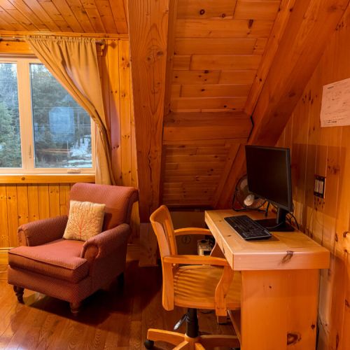 Stay connected with a rustic desk and comfy chair—perfect for remote work, creative escapes, or relaxing stays at your cozy lakefront vacation rental.