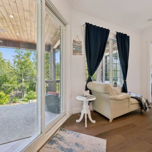 Large windows offering peaceful views of the surrounding trees and nearby water