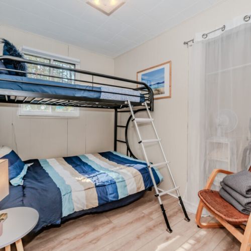 Family-friendly room with twin-over-double bunk bed, ideal for kids or friends—comfortable, cheerful, and close to cottage adventures.