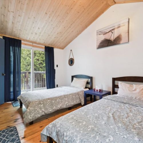 Bedroom 2: Cozy twin bedroom, ideal for kids or friends, with a warm and inviting cottage feel.