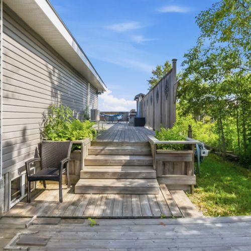 A quiet side deck with seating and lake access below. Perfect for morning coffee, fresh air, and relaxed coastal travel.