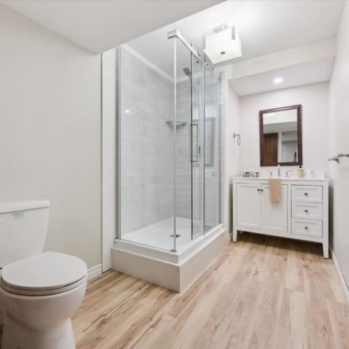 The updated bathroom features a modern glass shower and plenty of space to refresh in comfort.