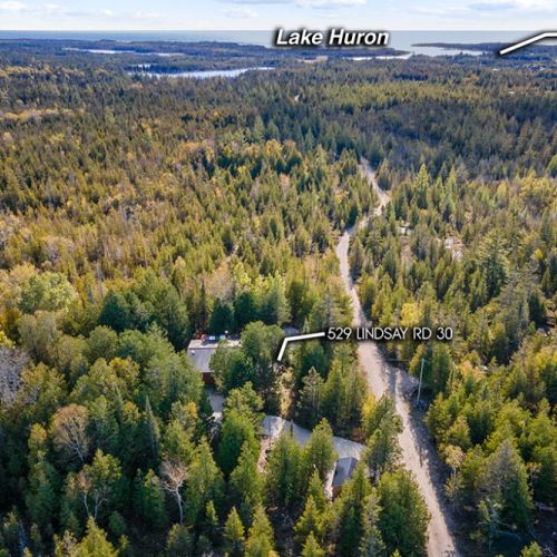 Set on nearly 4 private acres, the property is surrounded by peaceful cedar forest with Lake Huron just minutes away.