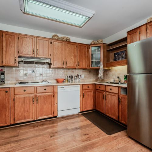 This spacious kitchen combines modern conveniences with rustic charm. The warm wooden cabinetry, ample counter space, and stainless steel appliances create a perfect environment for preparing meals. A built-in oven and microwave add to the kitchen’s functionality, while the adjacent dining nook is ideal for sharing a home-cooked meal or morning coffee with a view.