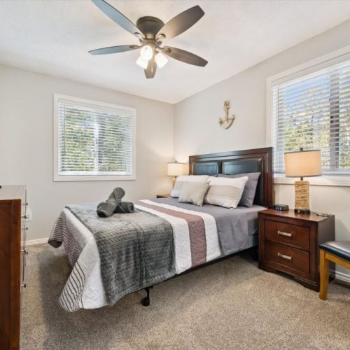Inviting bedroom retreat featuring cozy furnishings, large windows, and plenty of natural light.