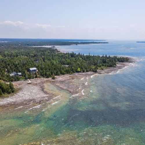 Crystal-clear Georgian Bay shoreline with shallow waters and rugged natural beauty.
