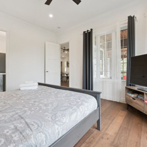 Bedroom 3: Spacious primary bedroom with king bed, bay windows, and plenty of natural light