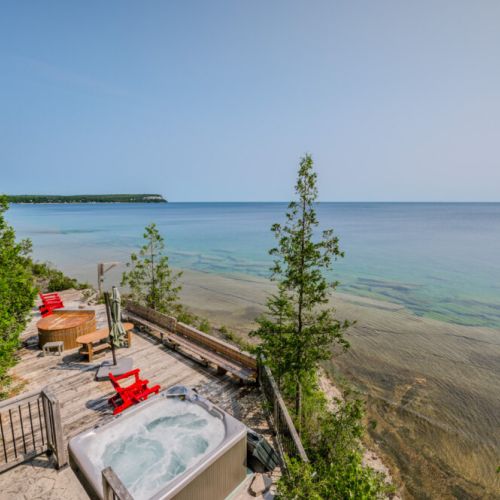 The property features luxurious outdoor amenities including a hot tub and sauna, providing the ultimate relaxation experience while enjoying the serene landscape.