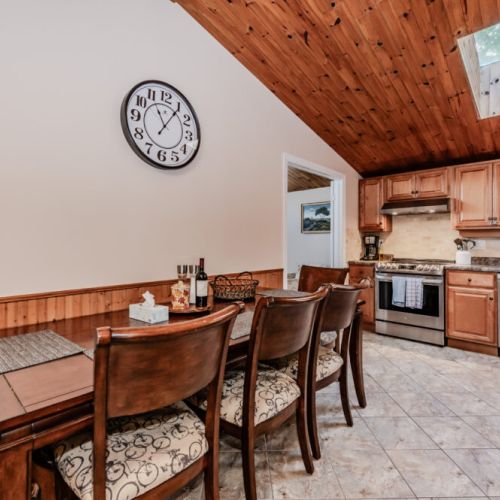 The dining area provides a warm and intimate setting, perfect for family meals, under the charm of wood-paneled ceilings.