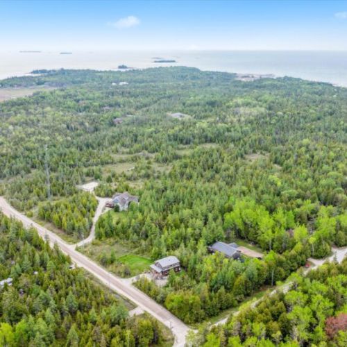 From this sweeping drone view, you can see how close the cottage is to the Lake Huron shoreline—just minutes away. Surrounded by unspoiled forest, this private oasis is your perfect launch point for exploring beaches, trails, and sunsets.
