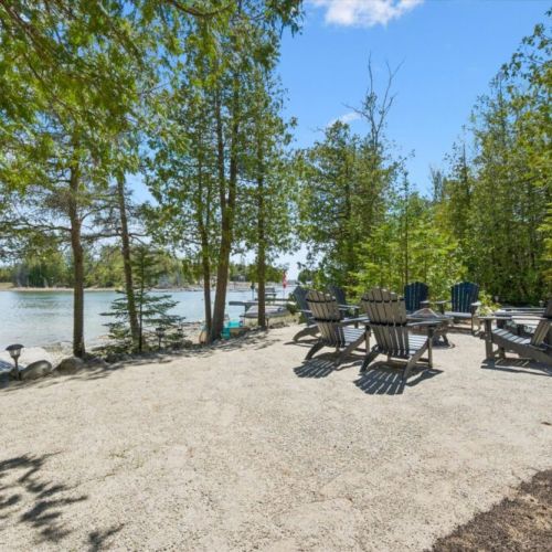 Spacious outdoor gathering area surrounded by nature, perfect for relaxing by the water with family and friends.