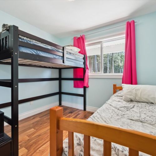 Perfect for families, the bunk room provides flexible sleeping arrangements and bright forest views.