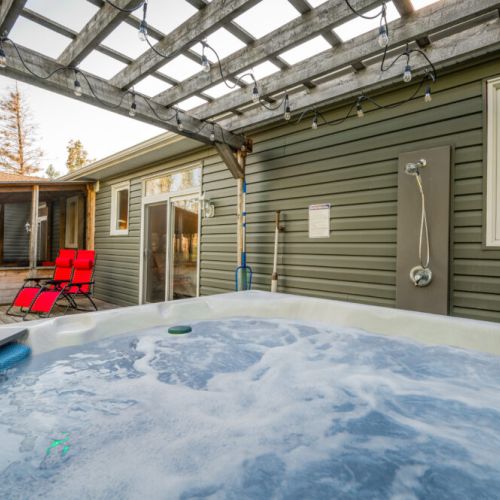 Soak in the private hot tub under a pergola with string lights and rinse off with the outdoor shower. Perfect for a spa-inspired getaway in cottage country.