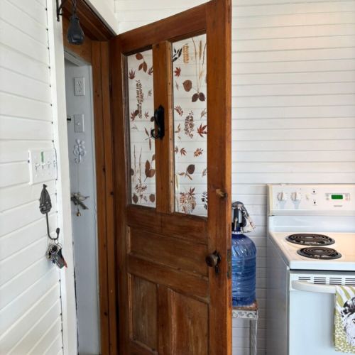 Vintage wooden door with nature-inspired panels adds cottage character.