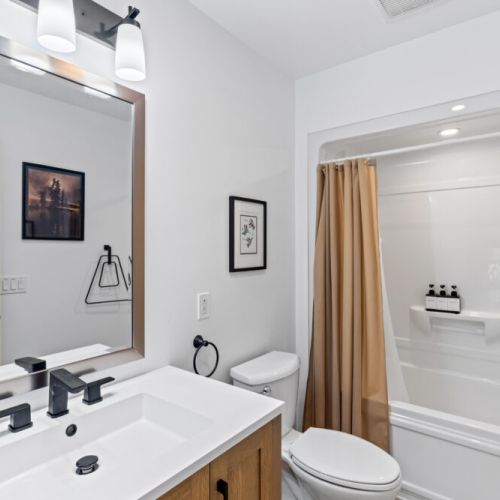 The main bathroom features a full tub and shower combination with modern finishes.